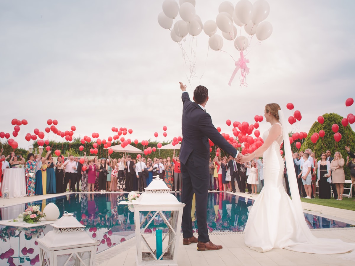 Digitale Hochzeitseinladung Beispiel: Brautpaar lässt Luftballons am Pool steigen – Hochzeitswebseite von Laura & Benny